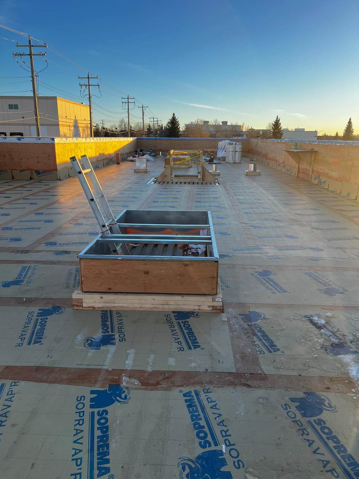 Commercial_Roofing_Replacement Commercial flat roof replacement with new membrane system being installed on a Calgary business