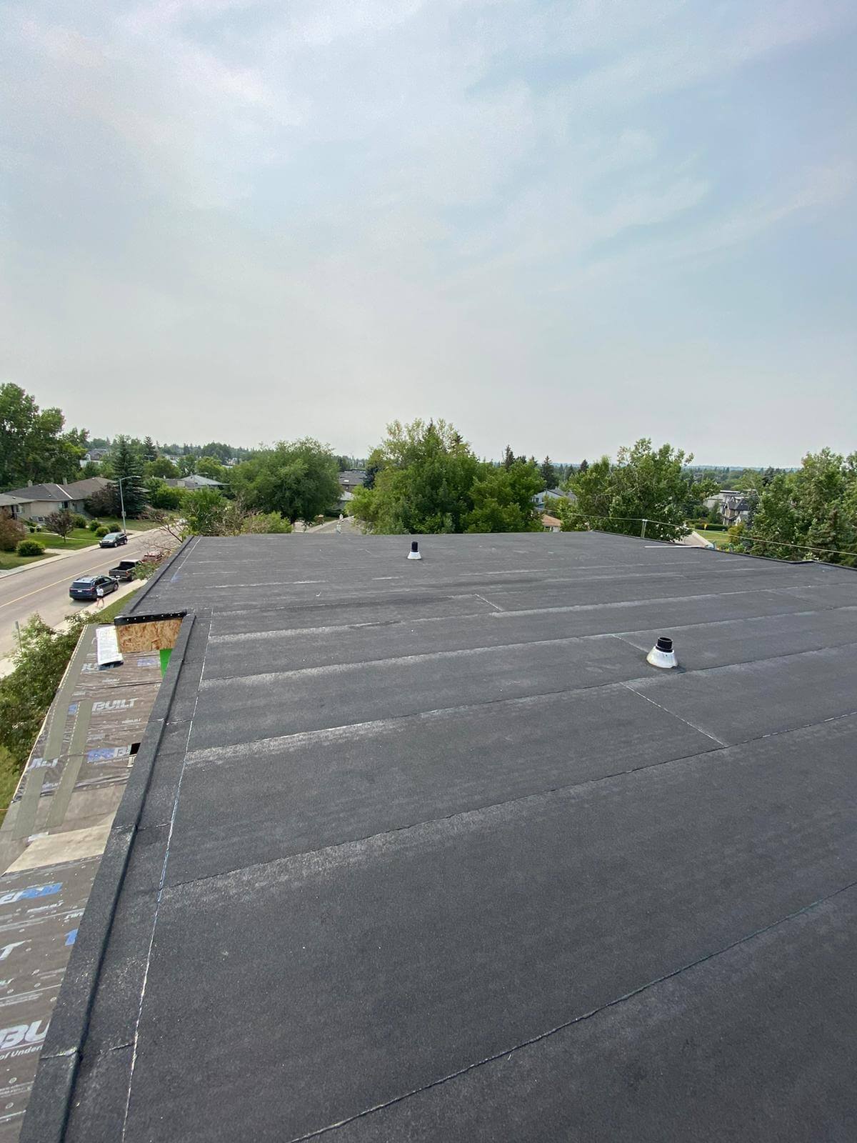 Flat roof undergoing preventative maintenance inspection with proper drainage and membrane condition check