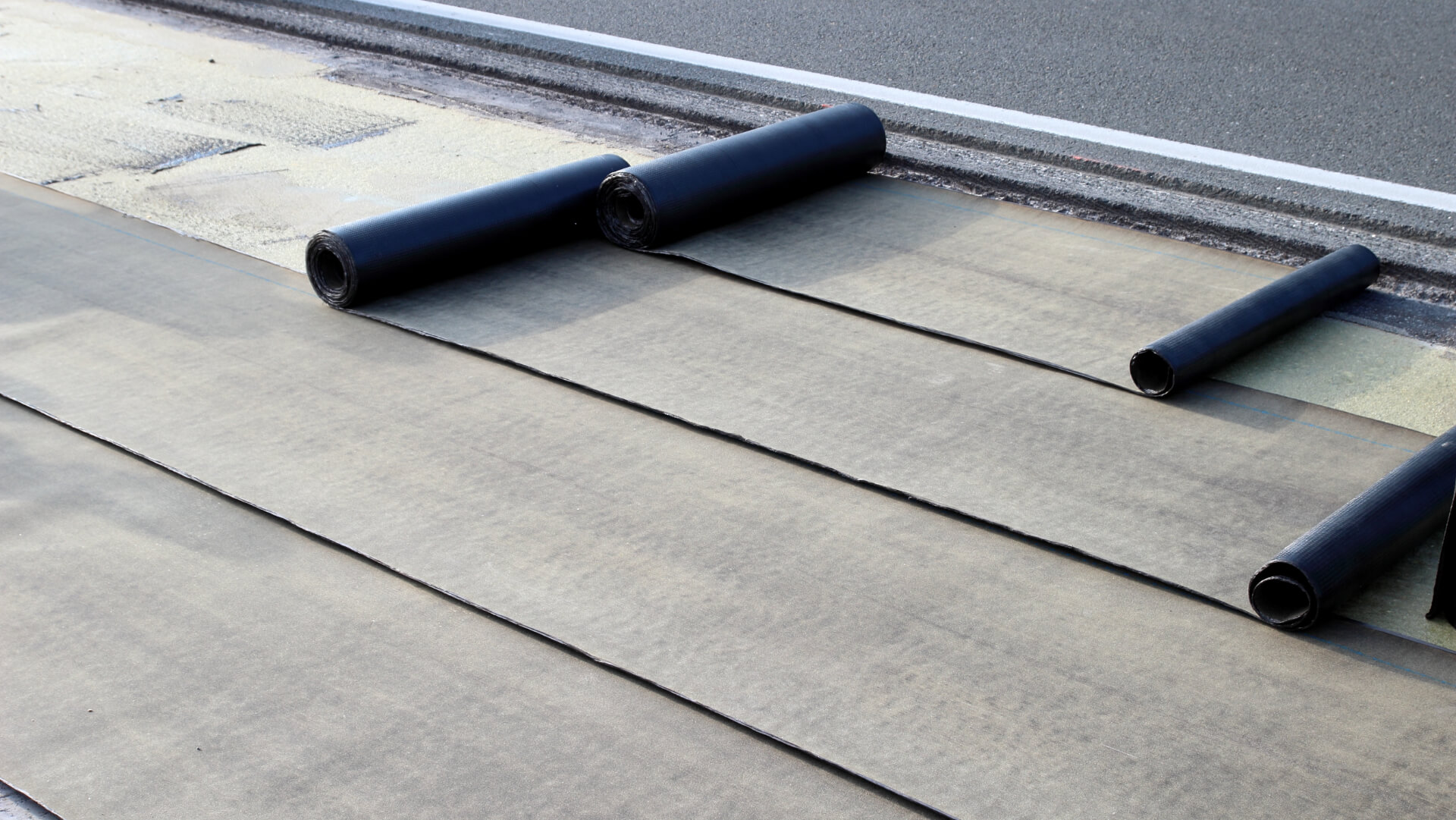 SBS modified bitumen membrane rolls laid out on a flat roof during installation